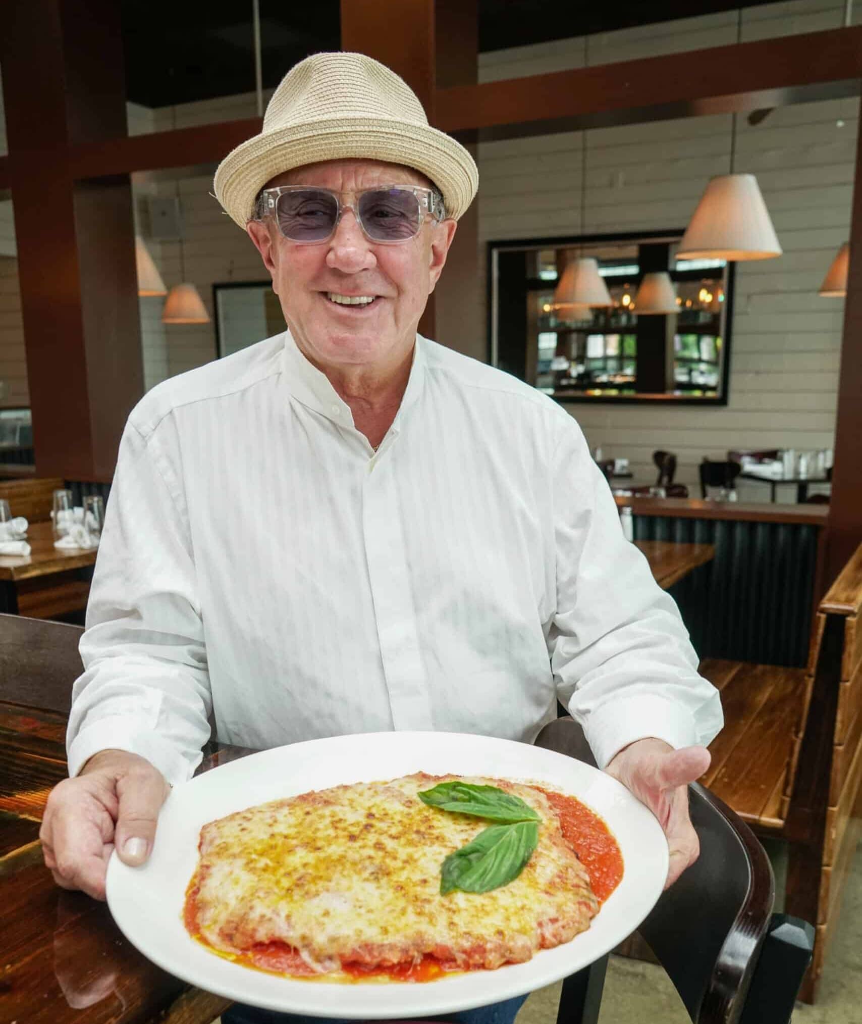 Rosebud’s founder, Alex Dana holding a large plate of food